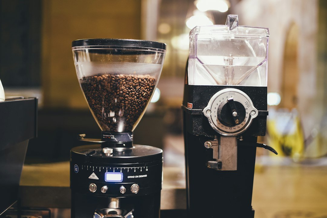 Coffee grinder being used with coffee beans.