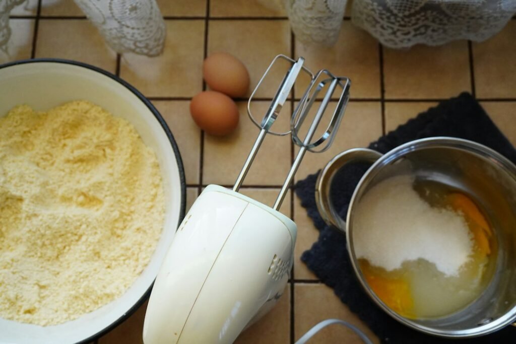 Baking ingredients with eggs and an electric mixer.