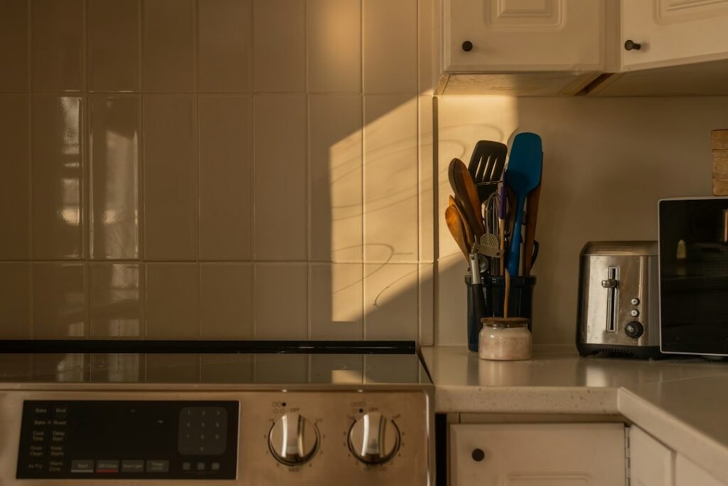 Kitchen counter with utensils and a toaster at sunset.
