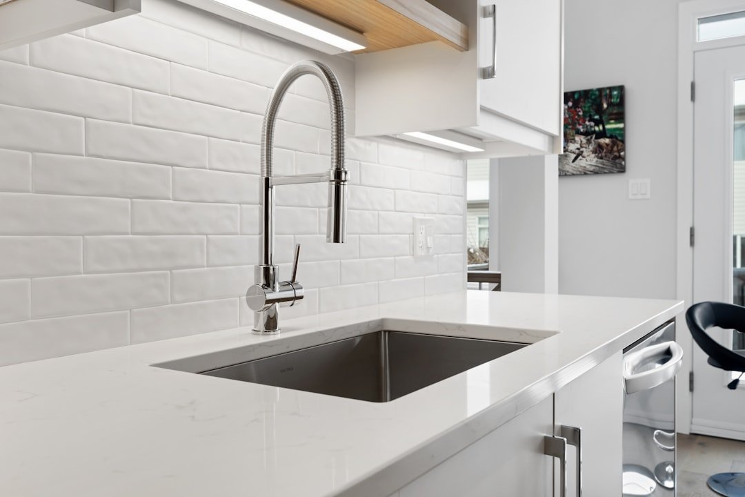 Pull-down style kitchen faucet and sink requiring a model-specific dishwasher adapter check