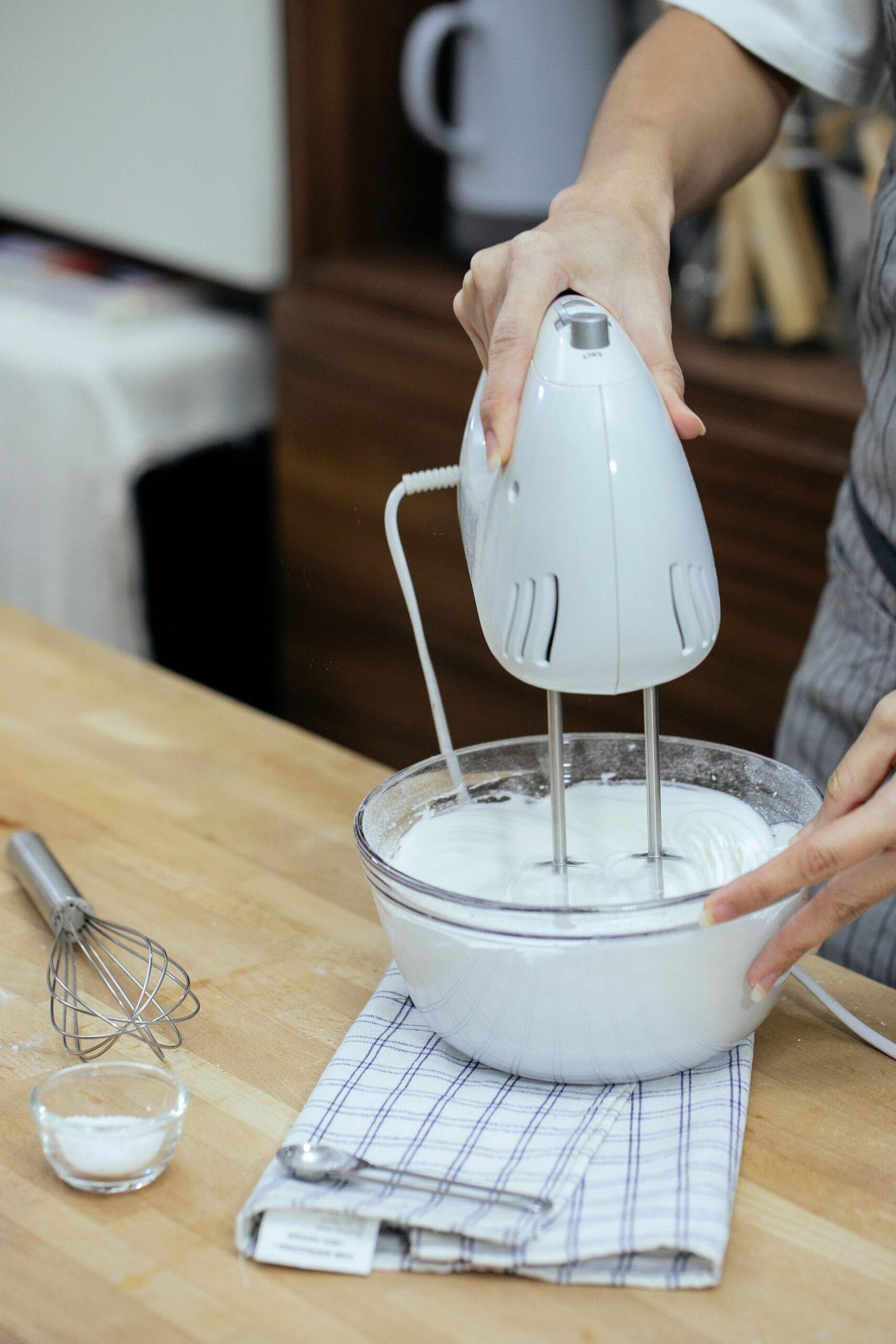 Hand mixer mixing batter in a bowl.